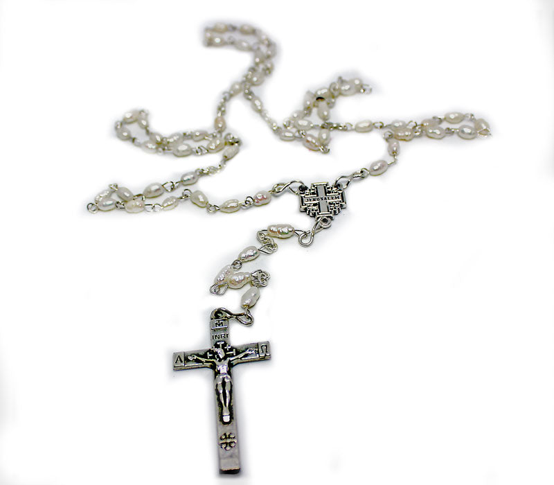 A silver-plated metal rosary with natural rice pearl beads and a cross emblem.