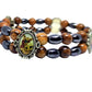 Multicolored beaded bracelet with an emblem featuring a religious figure on a white background