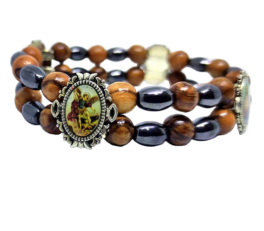 Multicolored beaded bracelet with an emblem featuring a religious figure on a white background