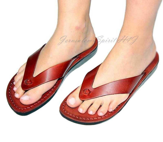 Red sandals worn on feet with a white background