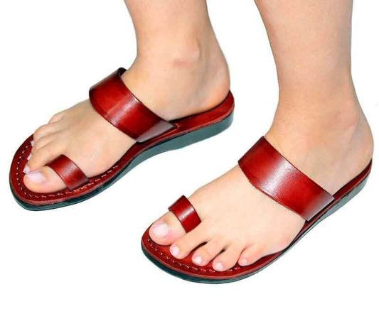 Red sandals worn on feet against a white background