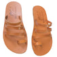 Pair of tan sandals with multiple straps on a white background