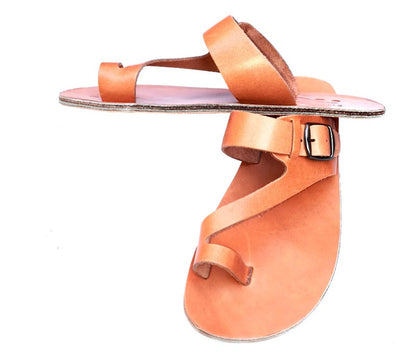 Tan sandal with a strap and buckle on a white background