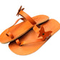 Pair of orange sandals with decorative elements on a white background