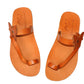 Pair of orange sandals with butterfly straps on a white background